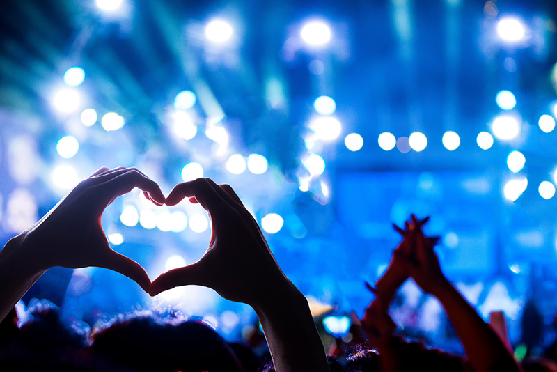 stock image of hands making a heart at concert